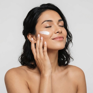 Vrouw brengt de ERAYS. Glow Lock Moisturizer aan op haar gezicht als laatste stap van haar skincare routine.
